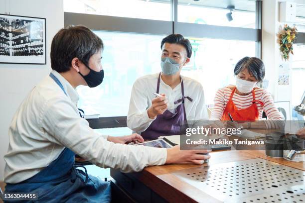 members of a family-owned wine store discussing their products, during covid-19 - business meeting with masks stock pictures, royalty-free photos & images