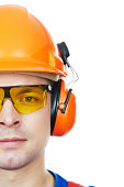 builder in hard hat, earmuffs and goggles