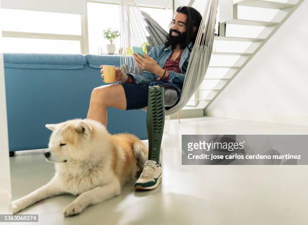 man with his dog at home with prosthetic leg - clock person desk stockfoto's en -beelden