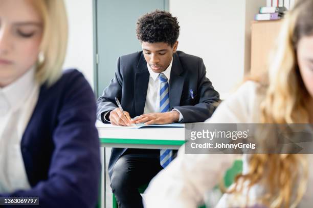 teenage students taking educational exam in classroom - blue blazer stock pictures, royalty-free photos & images