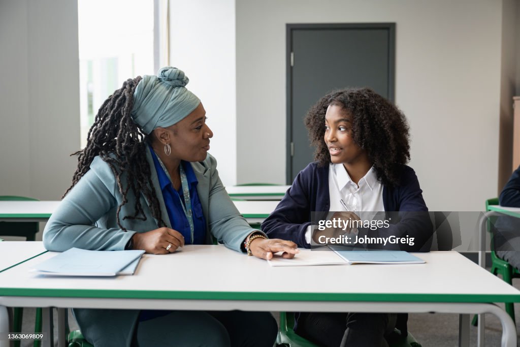 Schwarzer Pädagoge, der mit multirassischen Schülern im Klassenzimmer arbeitet