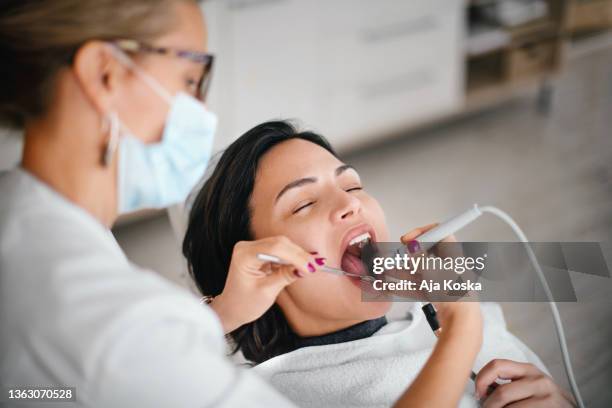 dentist removing dental calculus. - strip stock pictures, royalty-free photos & images