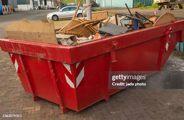 red waste container in a port area - müllcontainer stock-fotos und bilder