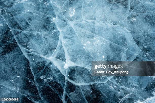 beautiful cracks surface of the frozen lake of baikal lake in winter season. - frozen man stock-fotos und bilder