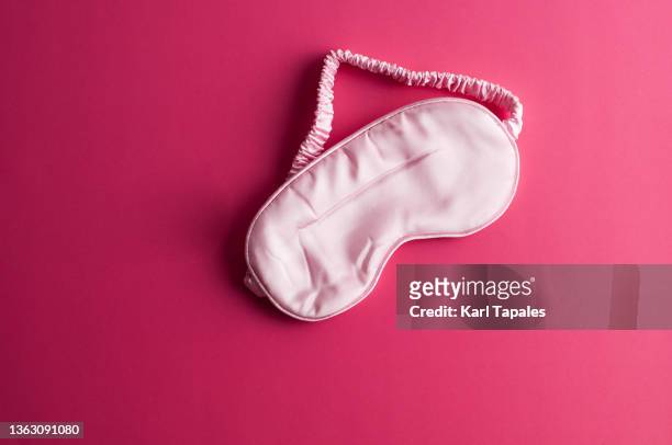 flat lay of eye cover on a pink background - fond usé photos et images de collection