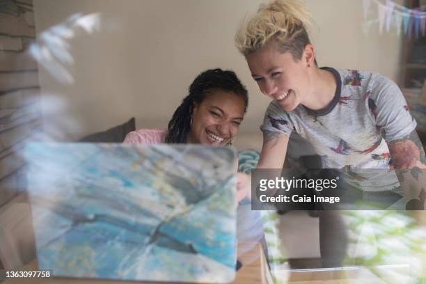 happy young female entrepreneurs working at laptop - caiaimage stock-fotos und bilder