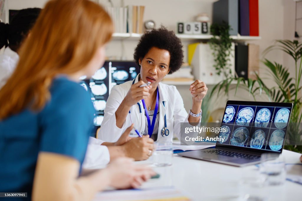 Radiologist Reading A Ct Scan To A Group Of Medical Practitioners High ...