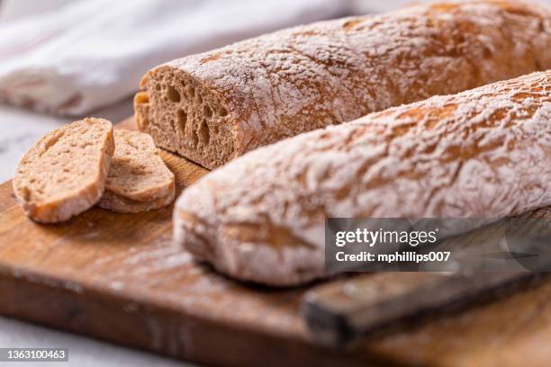 rustic italian ciabatta bread loaves on cutting board - chopping block flour stock pictures, royalty-free photos & images