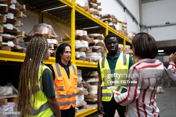 manager having an informal meeting with the team in a warehouse - androgynous professional stock pictures, royalty-free photos & images