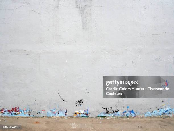 empty and patinated white concrete wall and brown sidewalk in paris - old wall stock pictures, royalty-free photos & images