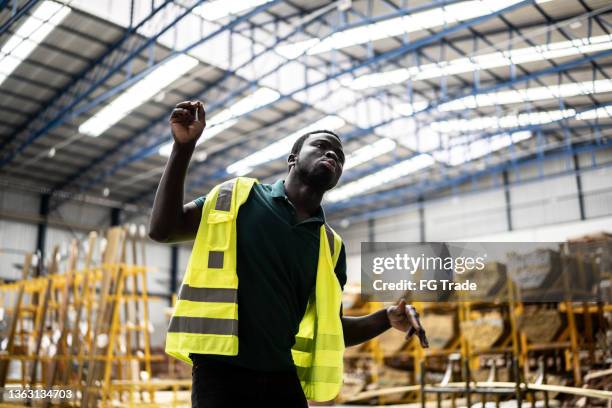 happy young man dancing while working in a factory - staff wellbeing stock pictures, royalty-free photos & images