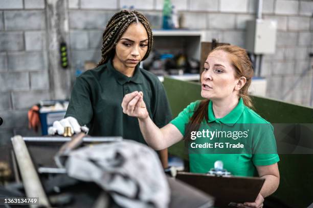 inspektor im gespräch mit produktionslinienarbeiter in einer fabrik / branche - industriearbeiter stock-fotos und bilder