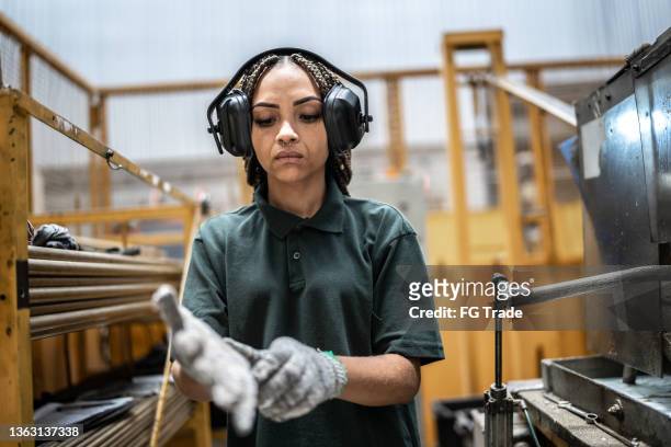 woman wearing gloves getting ready to work in a factory/industry - ear protection 個照片及圖片檔