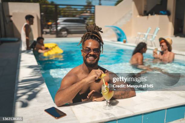 men drinking fruit cocktail in the pool - black people cocktail party stockfoto's en -beelden