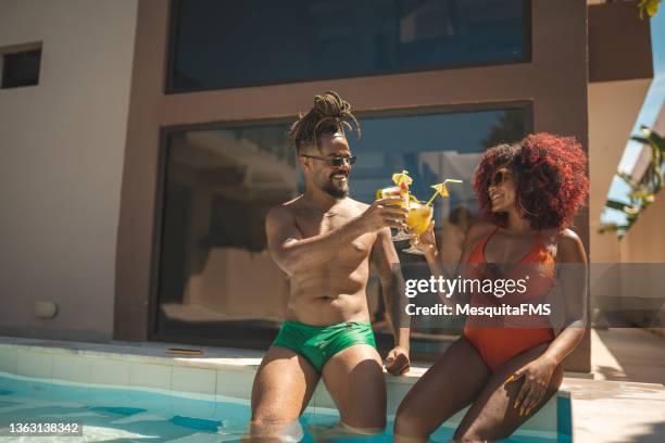 afro couple having a tropical cocktail at the pool - pool refreshment stock pictures, royalty-free photos & images
