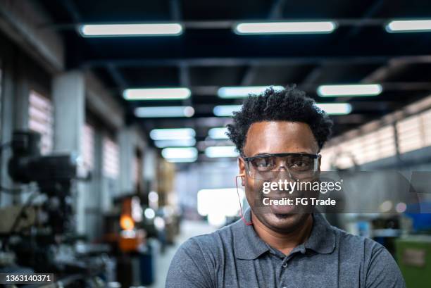 retrato de un hombre adulto medio en una fábrica - orejeras fotografías e imágenes de stock