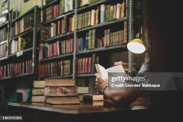 man reading a book in library - spanish literature stock pictures, royalty-free photos & images