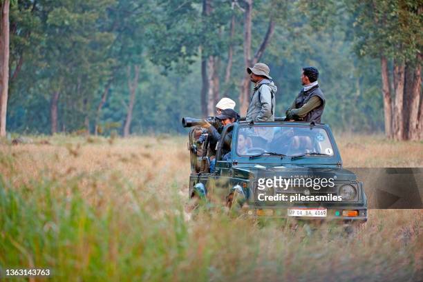 tourists and tracker share open-topped jeep off road 4x4 for animal viewing in kanha national park, madhya pradesh, india - wildlife reserve stock pictures, royalty-free photos & images
