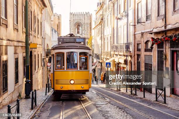 yellow tram in alfama, lisbon, portugal - lisbon fotografías e imágenes de stock