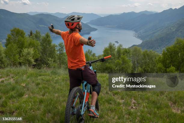 glückliche mountainbiker-arme auf dem berggipfel ausgestreckt, die freiheit und natur feiern - mountain biker stock-fotos und bilder