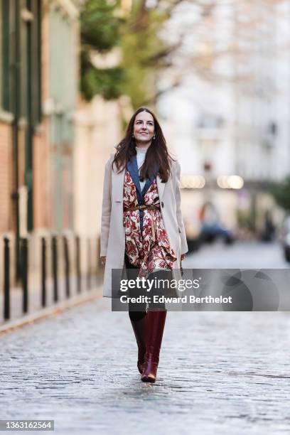 Alba Garavito Torre wears a blue vintage wool blazer jacket, a beige and burgundy floral print scarf over the blazer jacket, a turtleneck white...