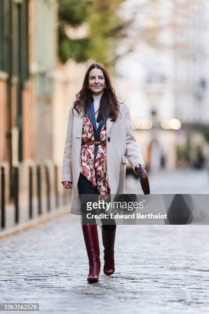 Alba Garavito Torre wears a blue vintage wool blazer jacket, a beige and burgundy floral print scarf over the blazer jacket, a turtleneck white...
