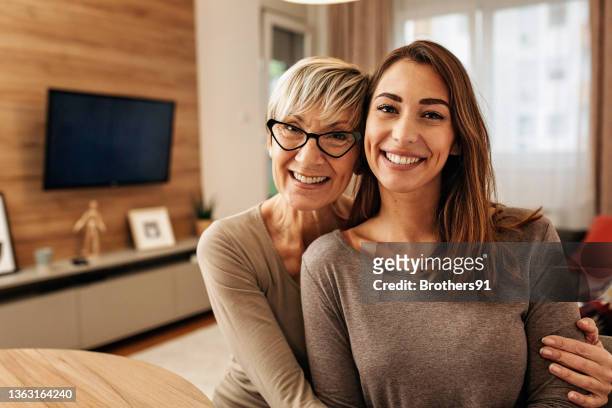 portrait of a caucasian mother and daughter bonding at home - life insurance stock pictures, royalty-free photos & images