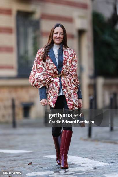 Alba Garavito Torre wears a blue vintage wool blazer jacket, a beige and burgundy floral print scarf over the blazer jacket, a turtleneck white...