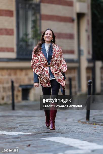 Alba Garavito Torre wears a blue vintage wool blazer jacket, a beige and burgundy floral print scarf over the blazer jacket, a turtleneck white...