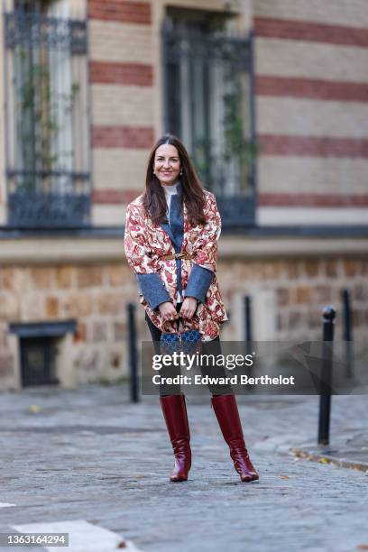 Alba Garavito Torre wears a blue vintage wool blazer jacket, a beige and burgundy floral print scarf over the blazer jacket, a turtleneck white...