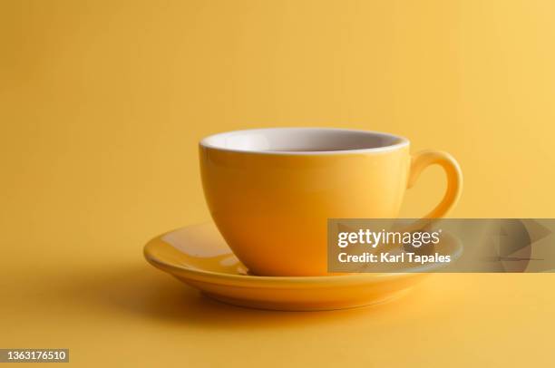 yellow coffee cup on a yellow background - coffee cup stock pictures, royalty-free photos & images