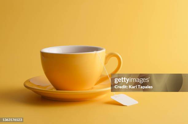 yellow tea cup on a yellow background - chávena de chá imagens e fotografias de stock