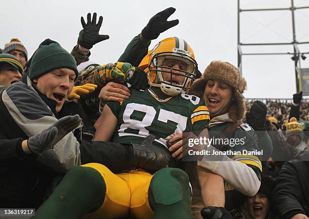 Jordy Nelson of the Green Bay Packers leaps into the stands after scoring a touchdown against the Detroit Lions at Lambeau Field on January 1, 2012...