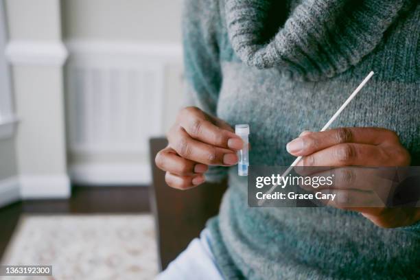 woman takes at-home covid test - cotton swab ストックフォトと画像