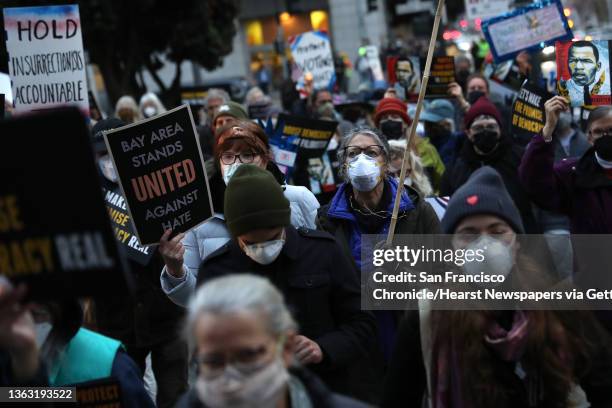 On the one year anniversary of the attack on the US Capitol, people march down Polk Street to the Department of Justice as Indivisible SF and...