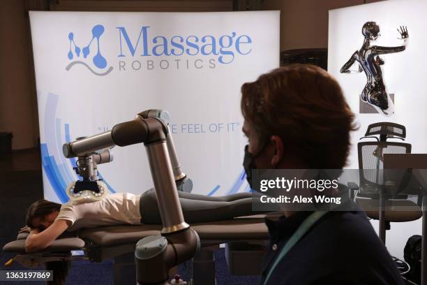 Product Manager Kriston MacKin demonstrates a massage robot at the Massage Robotics booth at CES 2022 at the Las Vegas Convention Center on January...