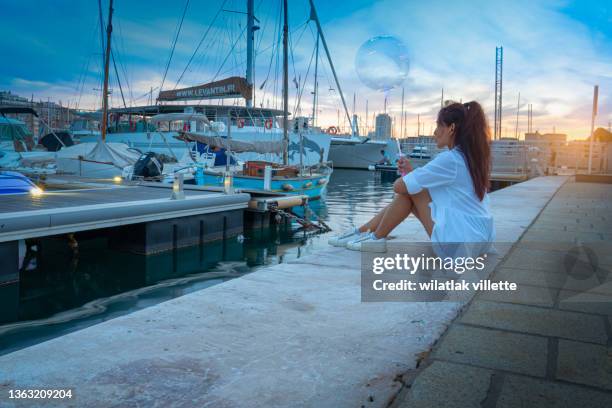 back view on young woman by the lake on the sunset. - 馬賽族 個照片及圖片檔