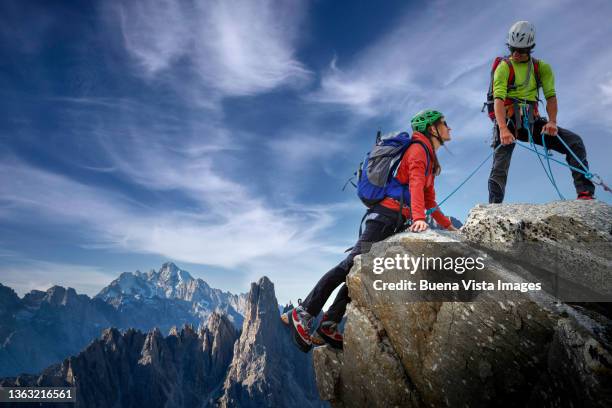 climbers couple on a mountaintop - team effort stock pictures, royalty-free photos & images