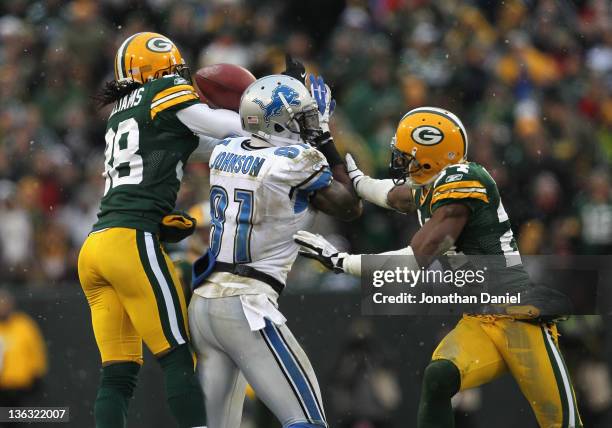 Tramon Williams of the Green Bay Packers breaks up a pass intended for Clavin Johnson of the Detroit Lions as Jarrett Bush also defends at Lambeau...