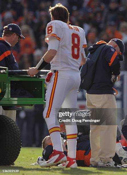 Quarterback Kyle Orton of the Kansas City Chiefs checks in on offensive guard Chris Kuper of the Denver Broncos after he suffered a leg injury and...