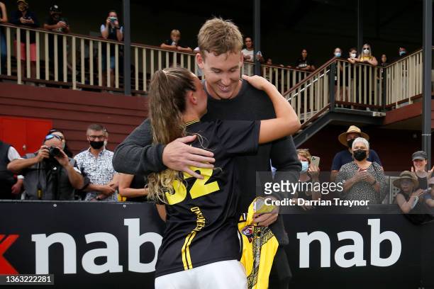 Tom J. Lynch of the Tigers presents his sister Bethany Lynch of Richmond with her jumper before during the round one AFLW match between the St Kilda...