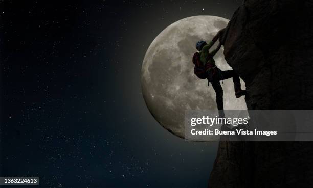 climber against full moon - vista posterior stockfoto's en -beelden