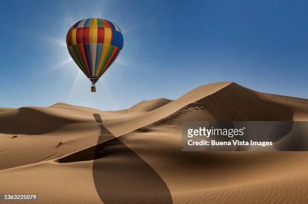hot air balloon over the desert at sunrise - vista posterior stockfoto's en -beelden