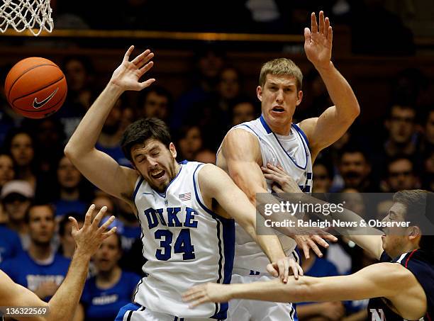 Duke forward Ryan Kelly and forward Mason Plumlee stop Pennsylvania guard Simeon Esprit from making it to the hoop in the first half at Cameron...