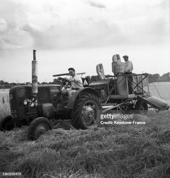 Un agriculteur pilote une Moissonneuse-Lieuse-Batteuse, le 11 juillet 1952.