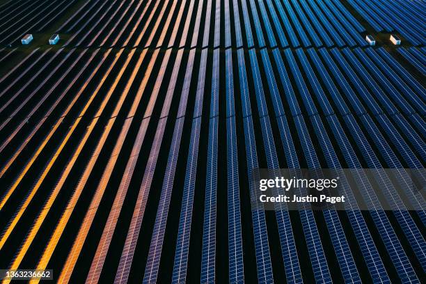 drone view over a field of solar panels at sunset - aerial view landscape stock pictures, royalty-free photos & images