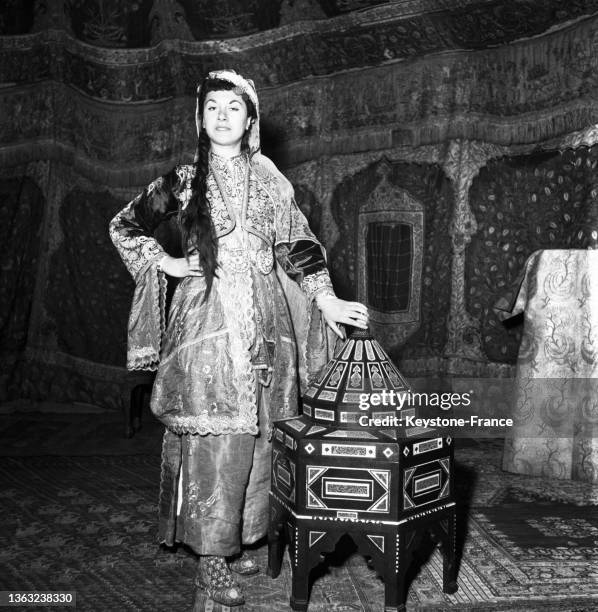 Une femme porte des objet d'arts turcs présentés pour une exposition d'art ancien au pavillon de Marsan, le 24 janvier 1953.