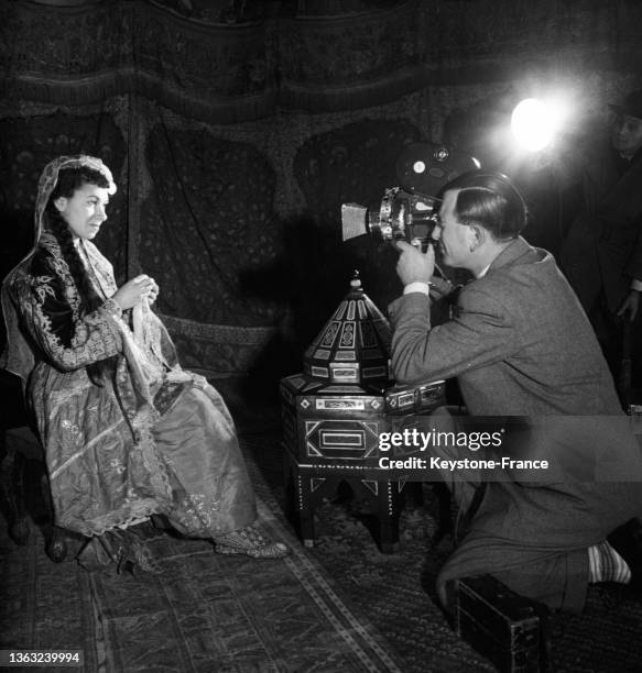 Un photographe shoot une femme porte des objet d'arts turcs présentés pour une exposition d'art ancien au pavillon de Marsan, le 24 janvier 1953.