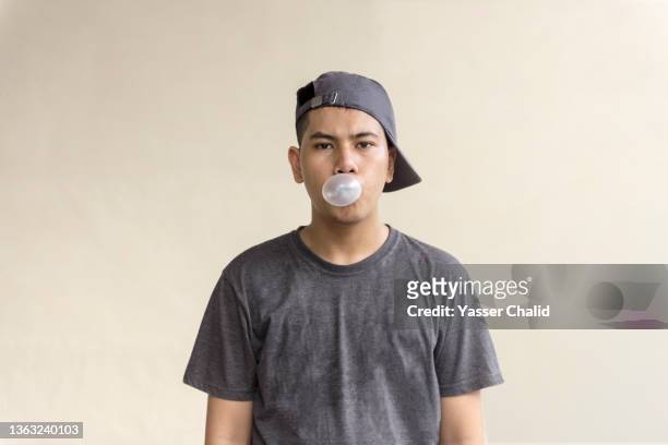 teenage boy portrait with bubble gum - andersherum stock-fotos und bilder