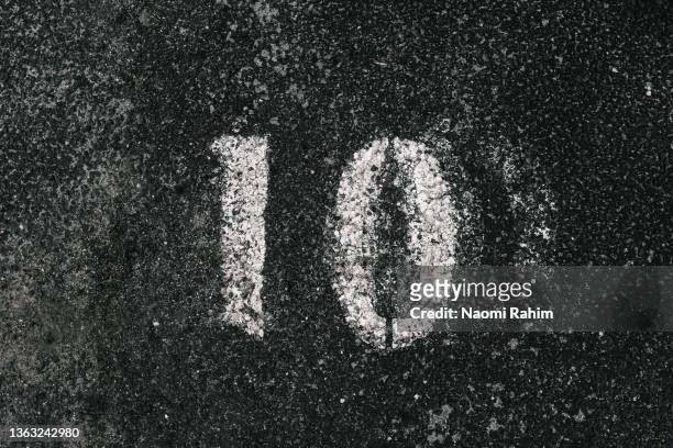 number 10 stencil spray painted onto tarmac - nombre 10 photos et images de collection